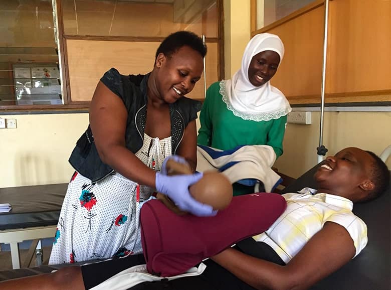 Midwife Justine doing a birth with Mama Natalie, Sarah, and students