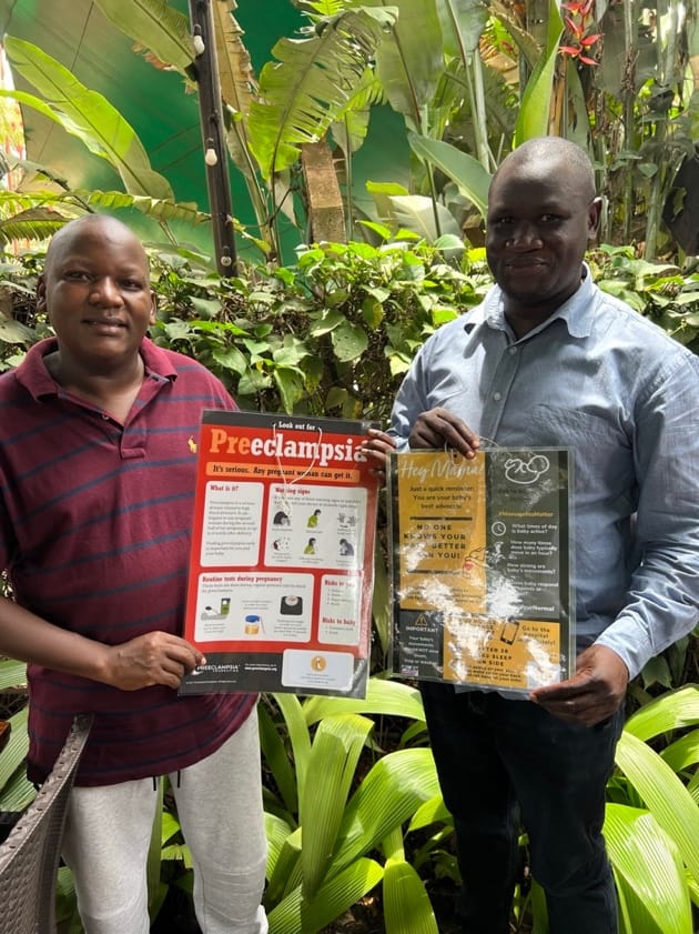 Mackay and Julius holding maternal related teaching posters